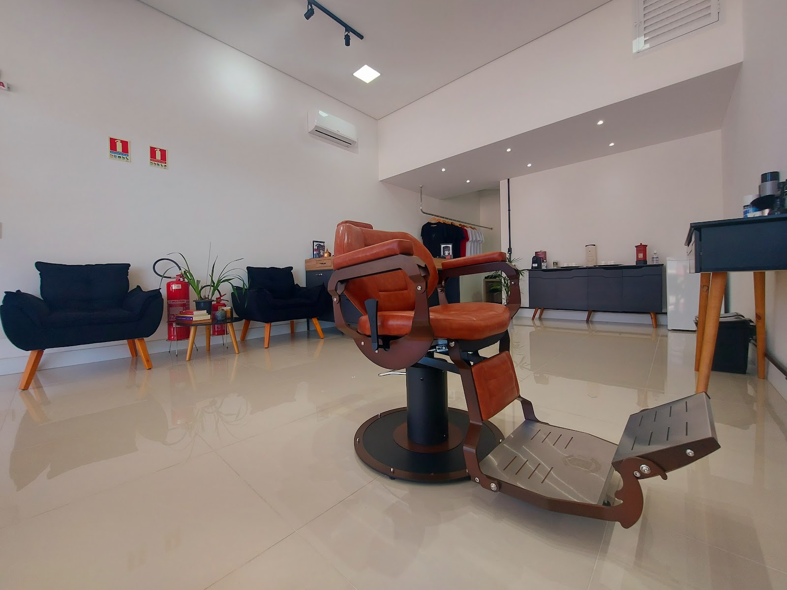 Sala de espera e cadeira de barbeiro da Barbearia Voullo