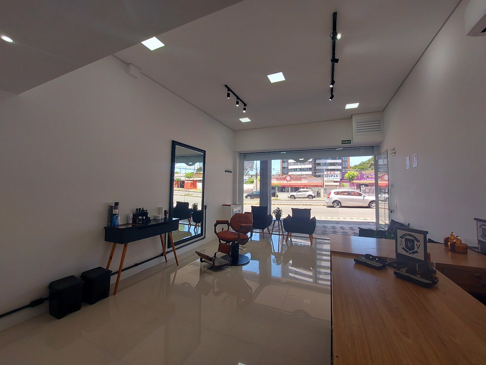 Sala de atendimento da Barbearia Voullo, com poltronas de espera ao fundo